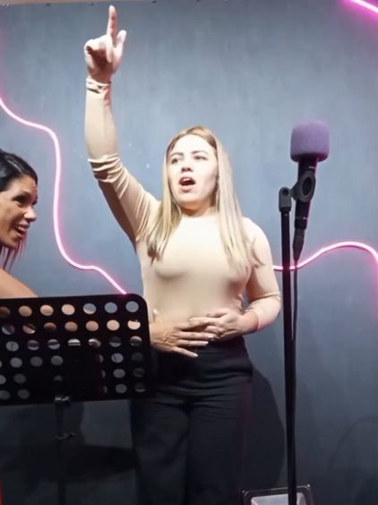 Aluna soltando a voz em nota aguda durante a aula